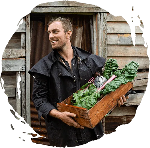 man holding wood box with leafy vegetable and tin can seeds