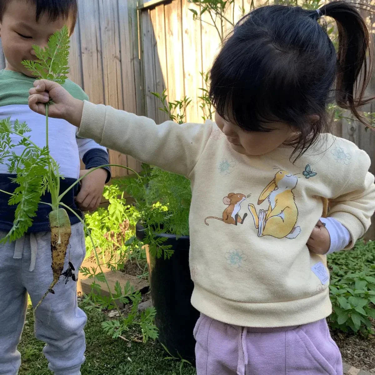 Kids gardening and harvesting fresh vegetables in a backyard, showcasing the "Seeds for Kids" kit benefits.