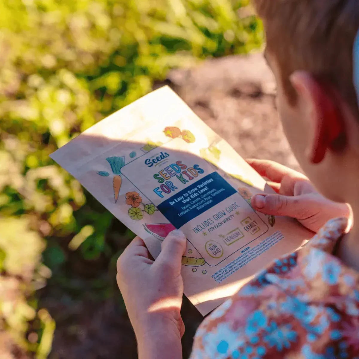 Child holding Seeds for Kids gardening kit outdoors.