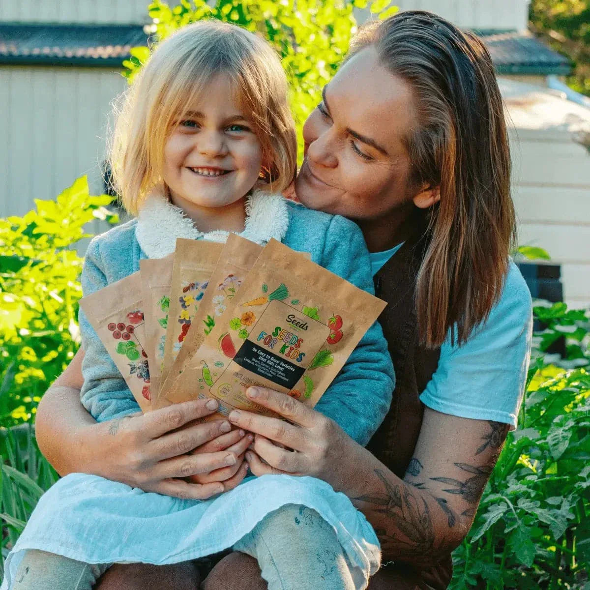 Parent and child enjoying gardening with 'Seeds for Kids' kit in a garden.